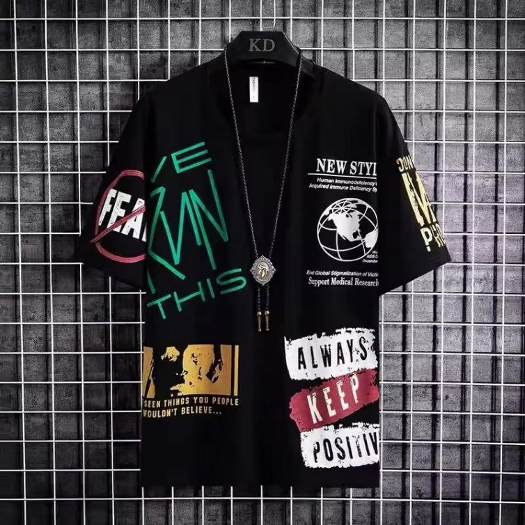 Black t-shirt with colorful text and graphics on a grid-patterned wall background